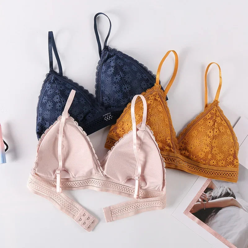 Three bras in navy, pink, and mustard yellow on a light background